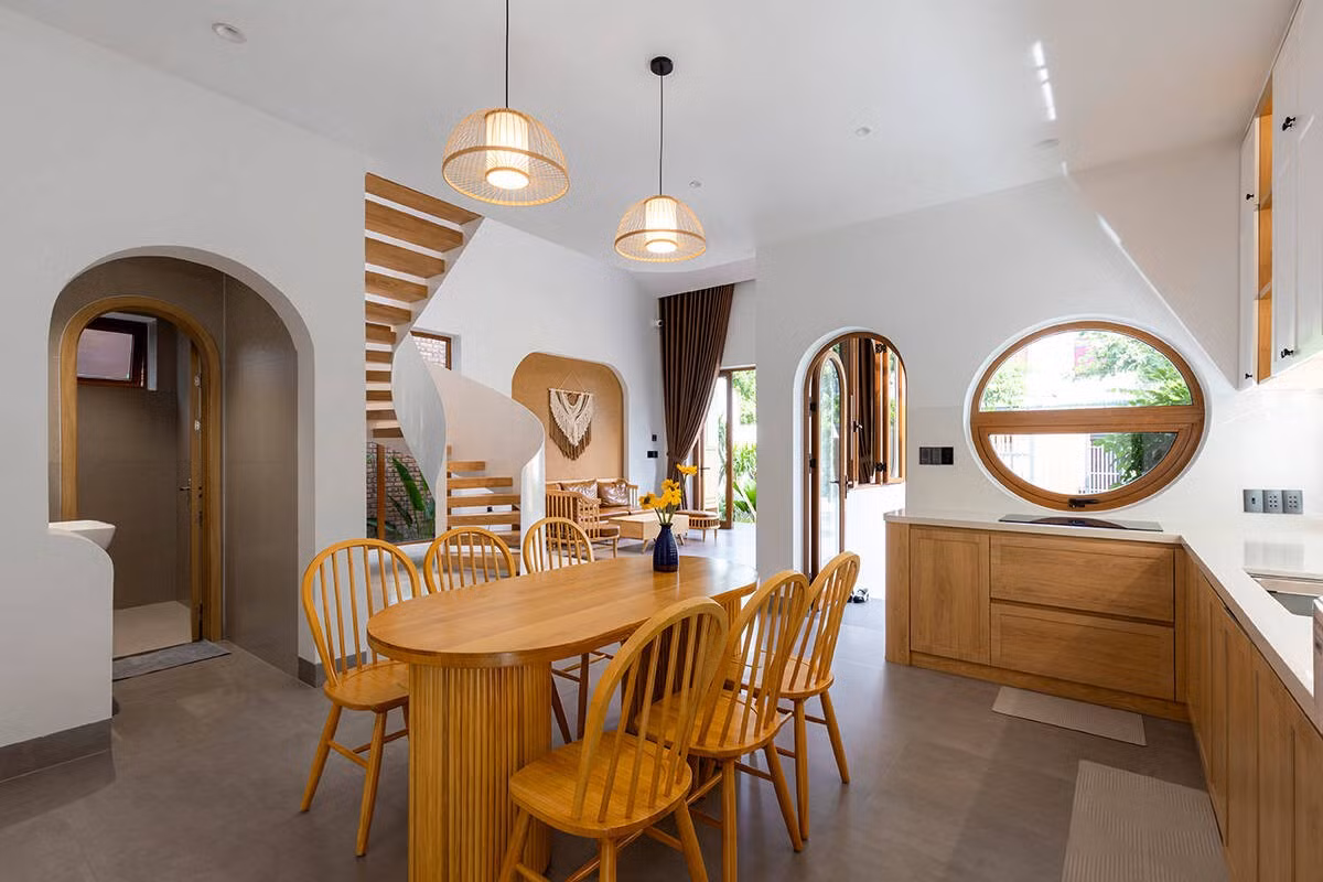 Trung tâm của tầng trệt là bếp với không gian mở hoàn toàn, kết nối trực tiếp với bàn ăn và khu vườn bên hông. Ảnh: Khánh Nguyễn