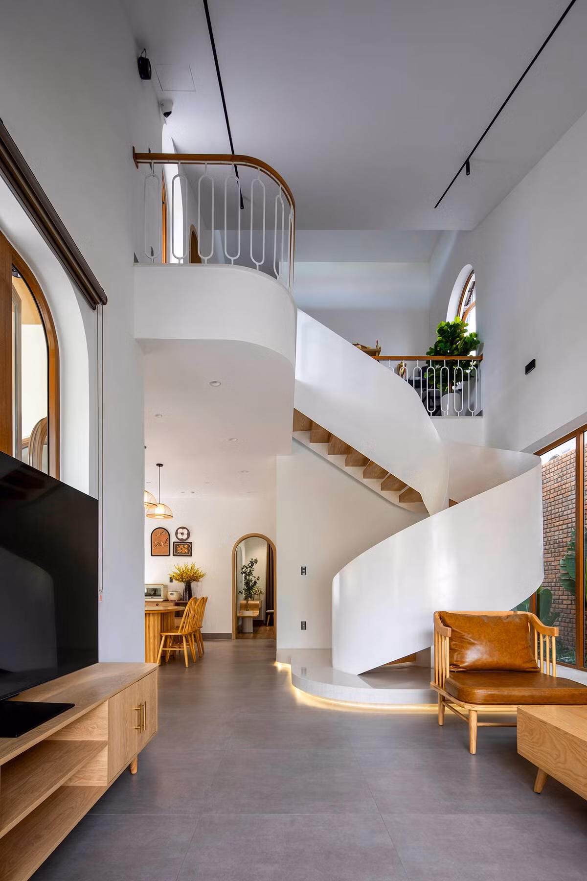 Những mảng tường bo cong, vòm cửa uốn mềm và vật liệu ấm áp như gỗ sáng, đá mài terrazzo... tạo nên một hệ ngôn ngữ thẩm mỹ nhất quán. Ảnh: Khánh Nguyễn