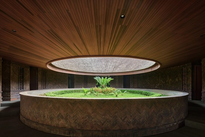 Không gian trung tâm được thiết kế như một khu vườn, bao quanh bởi những bức tường gạch. Trần nhà vòm cong rộng mở, tạo ra một cửa sổ lớn đón ánh sáng tự nhiên. Ảnh: Worldarchidesign