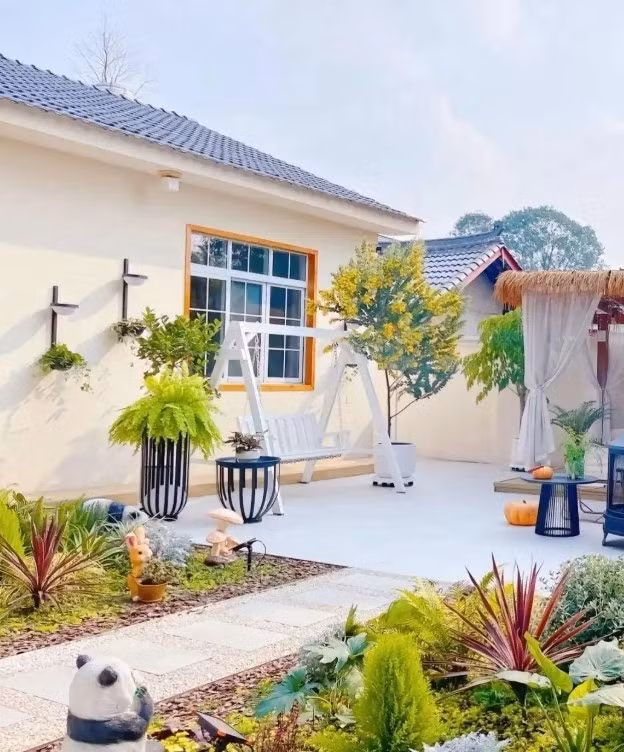 Bên ngoài, ngôi nhà nổi bật với tường sơn màu trắng sữa kết hợp mái xanh lam và cửa kính trong suốt. Ảnh: QQ