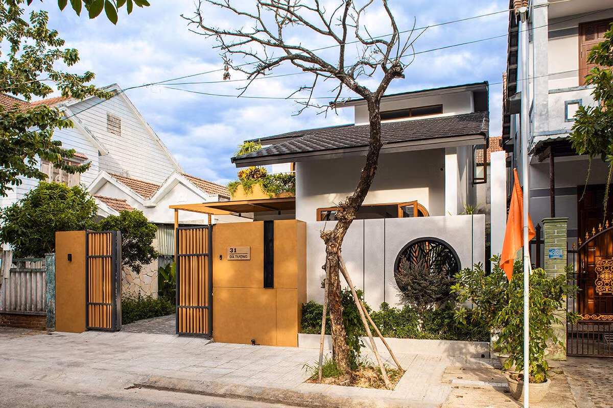 Mặt tiền ngôi nhà nổi bật với các chi tiết như ô cửa tròn, lam sắt và mảng tường màu đất nung... gợi nhắc yếu tố truyền thống trong một hình thức hiện đại. Ảnh: Khánh Nguyễn