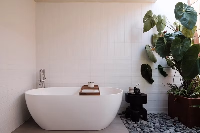 Bồn tắm độc lập đặt cạnh khoảng xanh nhỏ, được mở sáng và thông gió tự nhiên, mang lại cảm giác thư giãn như spa tại nhà. Ảnh: Archdaily