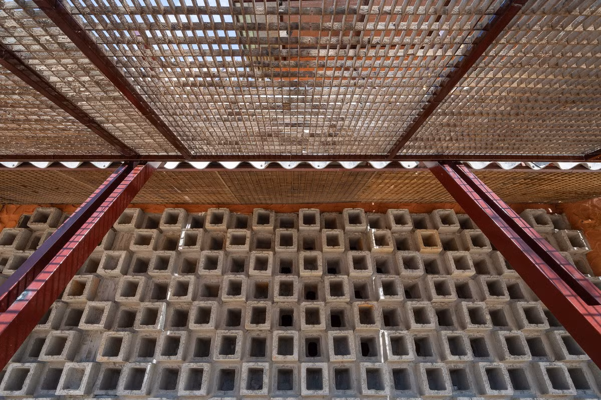 Những viên gạch không nung được xếp chồng thành một nhịp điệu giản dị nhưng đầy ấn tượng, nhiều kèo thép dựng nghiêng và những tấm fipro xi măng cũ, tạo điểm nhấn không gian liên tiếp cho mặt đứng của công trình. Ảnh: Quang Dam