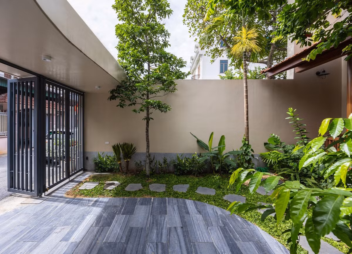 Con đường lát đá tự nhiên len giữa thảm cỏ xanh dẫn lối vào nhà, hai bên là những khóm hoa đủ màu... Ảnh: Triệu Chiến