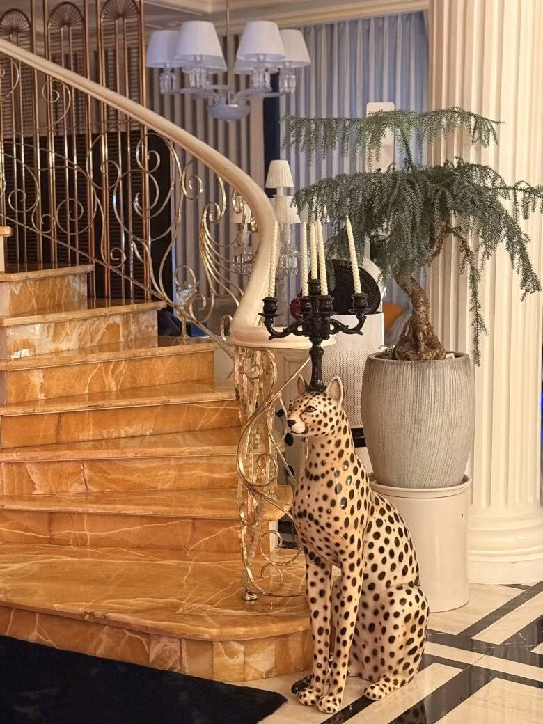 Cầu thang được ốp đá marble vàng vân nổi bật, tay vịn uốn lượn ánh kim. Ảnh: FBNV