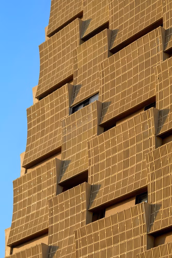 Những bức chắn cong xen kẽ theo chiều ngang và chiều dọc khắp tòa nhà, giúp chắn nắng, tạo ra không gian xanh mở cho mỗi phòng đồng thời mang lại vẻ đẹp độc đáo cho công trình. Ảnh: Vinay Panjwani