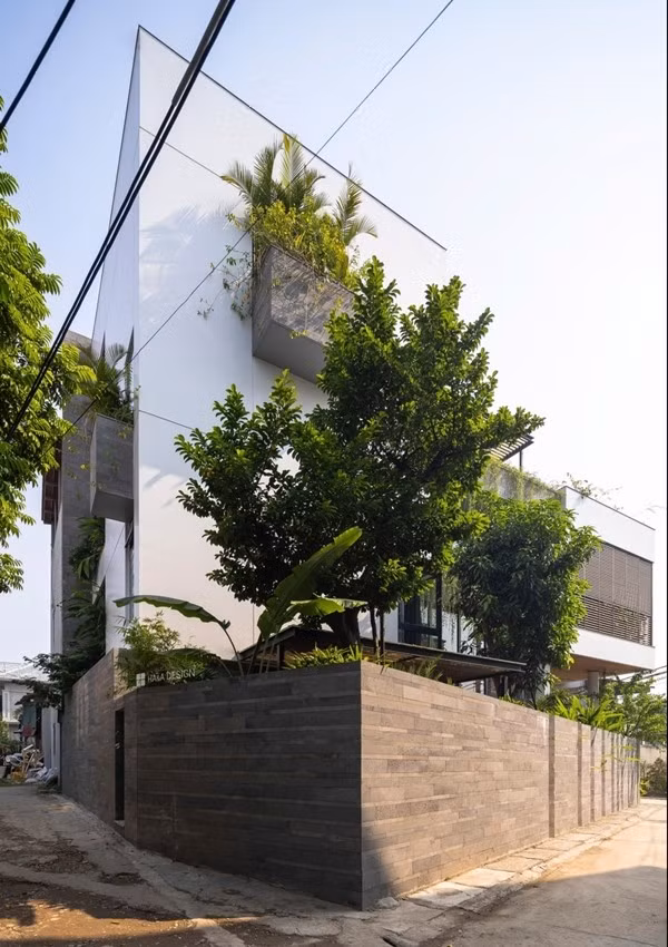 Hàng rào đá ong tạo sự đối lập với mảng tường sơn trắng làm giảm cảm giác nặng nề mang lại tổng thể chung nét kiến trúc hiện đại. Ảnh: Archdaily