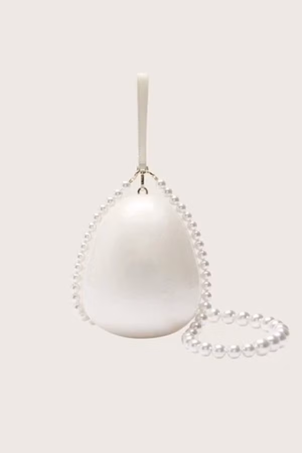 Chiếc túi này là thiết kế Pearl Egg Bag nổi tiếng của nhà mốt Simone Rocha. Túi được chế tác từ vật liệu bóng, tạo điểm nhấn với dây đính kết ngọc trai, giá gần 20 triệu đồng. Ảnh: Simone Rocha