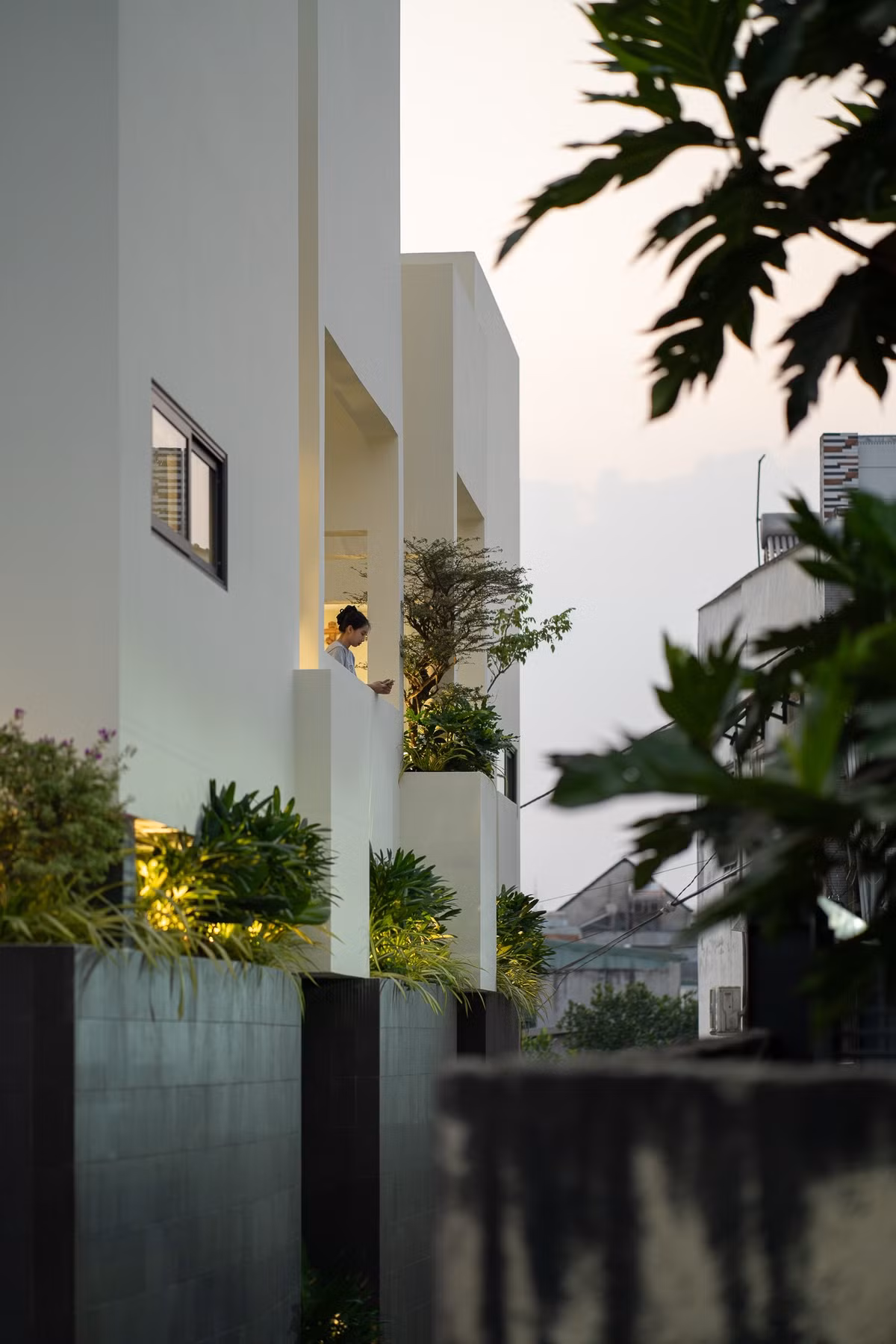 Thay vì lấp đầy diện tích bằng những mảng tường đặc, ngôi nhà chọn “khoảng rỗng” làm hạt nhân, như một nhịp thở len lỏi giữa những khối bê tông san sát. Ảnh: Quang Dam