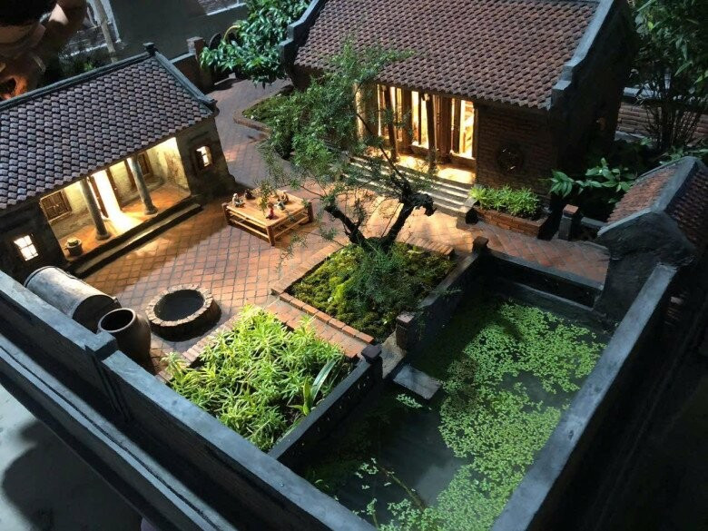 Mô hình nhà cổ với sân lát gạch đỏ, giếng nước, cây cảnh và ao nhỏ, tạo nên tổng thể bình dị và gần gũi. Ảnh: FB Xuân Hinh