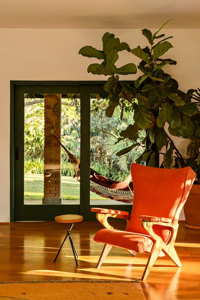 Khung cửa sổ được mở rộng giúp bảo tồn thiết kế và màu xanh lá cây đặc trưng của vùng, cho phép ánh sáng và không khí lưu thông khắp nhà. Ảnh: Joana França