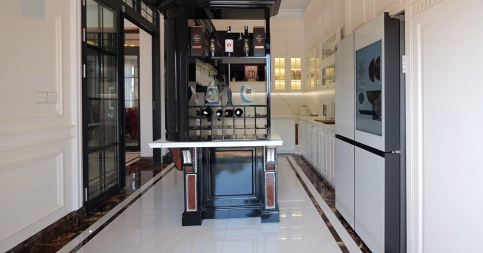 Khu vực bếp với gam màu trắng chủ đạo, có bàn đảo tích hợp quầy bar mini. Ảnh: Chụp màn hình