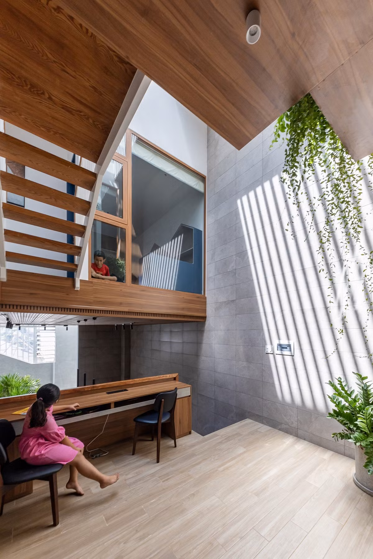 Các khoảng đệm, giếng trời được đưa vào giữa nhà giúp ánh sáng và không khí luân chuyển hiệu quả khắp 3 tầng. Ảnh: Minq Bui