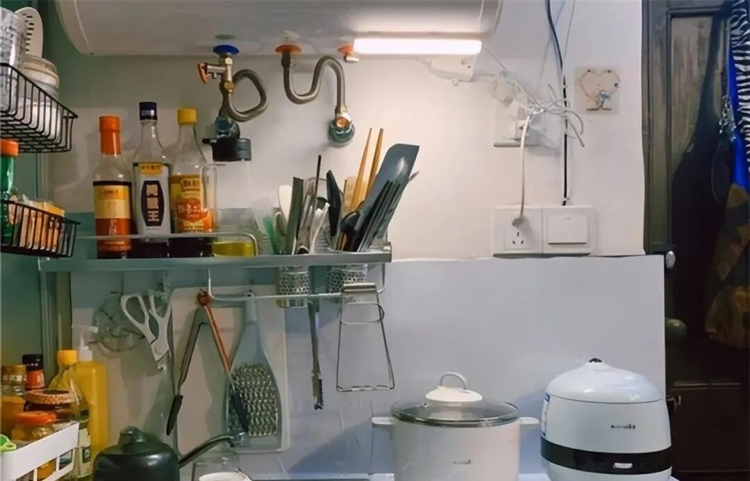 Khu bếp chật chội được sắp xếp gọn gàng với hệ tủ treo tường để chứa gia vị và đồ dùng nhà bếp. Ảnh: Toutiao