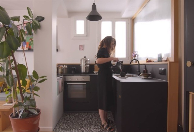 Khu bếp liền kề phòng khách với thiết kế bàn bếp chữ L màu đen. Ảnh: Toutiao