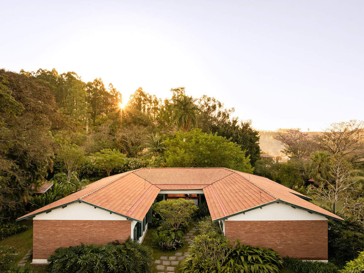 Dự án cải tạo được triển khai trên tổng diện tích sàn khoảng 600 m2. Phần can thiệp tập trung vào việc giữ nguyên mái ngói đất nung, hệ mái đua rộng và hình dạng chữ U, đồng thời sắp xếp lại không gian nhằm đáp ứng nhu cầu sinh hoạt mới. Ảnh: Joana França