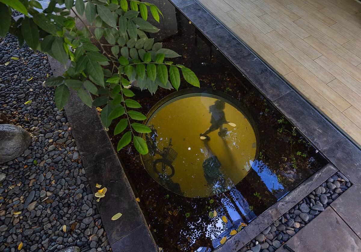 Giải pháp “điều hoà không khí” tự nhiên là một điểm nhấn đặc biệt. Giếng trời lớn kết hợp mặt nước và hồ Koi phía Đông Nam giúp không khí lưu chuyển, tạo cảm giác mát mẻ. Ảnh: Triệu Chiến