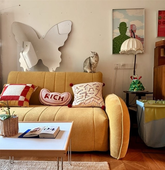 Phòng khách nhỏ nhưng tiện nghi với sofa, bàn trà nhỏ và tủ để máy chiếu. Ảnh: Toutiao