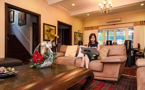 Phòng khách với gam màu trầm chủ đạo kết hợp đèn chùm sang trọng. Ảnh: Dân Việt