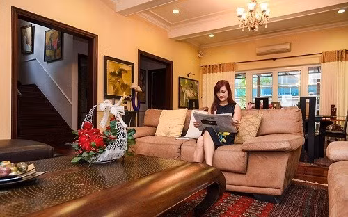 Phòng khách với gam màu trầm chủ đạo kết hợp đèn chùm sang trọng. Ảnh: Dân Việt