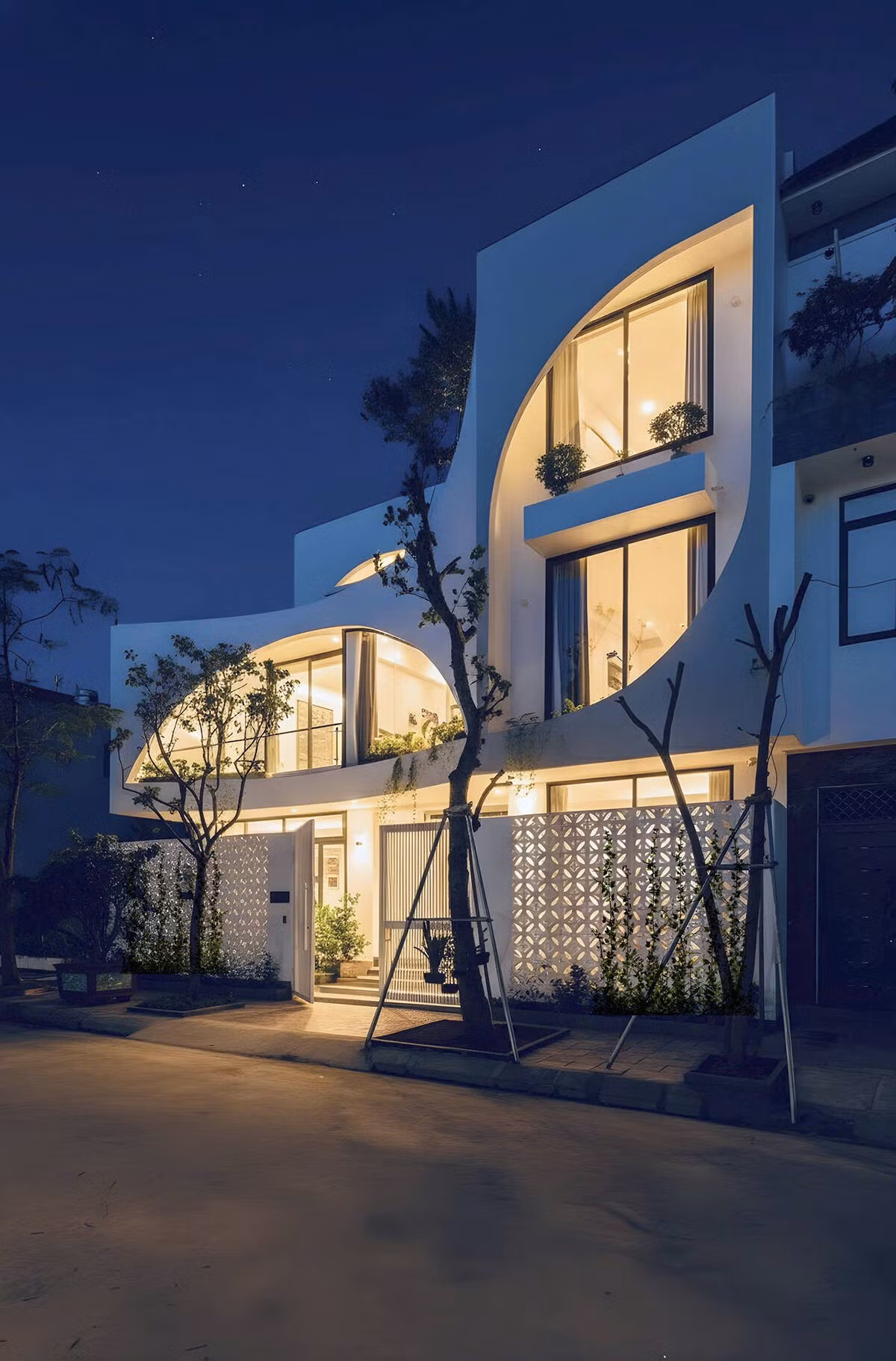 Mặt tiền là sự kết hợp giữa các khối trắng với những đường cong mềm mại, tạo nên bố cục vừa mạnh mẽ vừa duyên dáng, giúp công trình nổi bật giữa khu phố. Ảnh: NguyenhieuARC