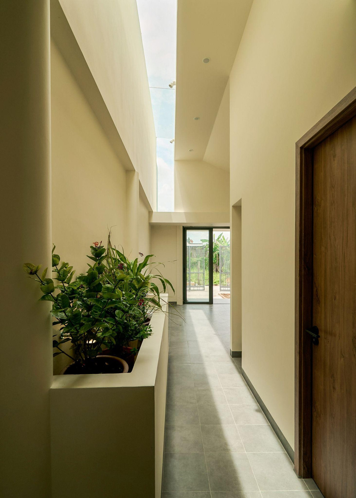 Khe sáng được bố trí khéo léo giáp vách tường cao của nhà bên cạnh, giúp cắt nắng sau giờ trưa và tận dụng ánh sáng tự nhiên vừa đủ. Ảnh: Nam Võ