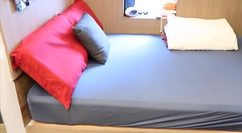 Giường ngủ được kê sát tường, cạnh một ô cửa sổ nhỏ để đón ánh sáng. Ảnh: Toutiao