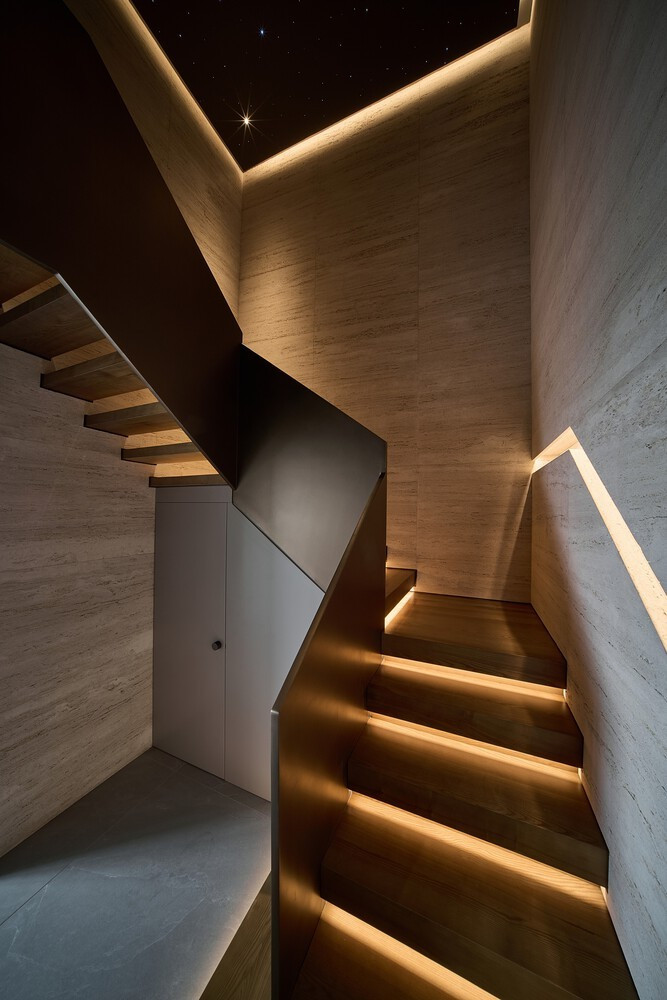 Ở hai đầu, một cầu thang thẳng và một cầu thang xoắn tạo kết nối liên tục giữa hai tầng, cho phép dòng lưu thông xuyên suốt toàn bộ công trình. Ảnh: Wuyhoang Studio