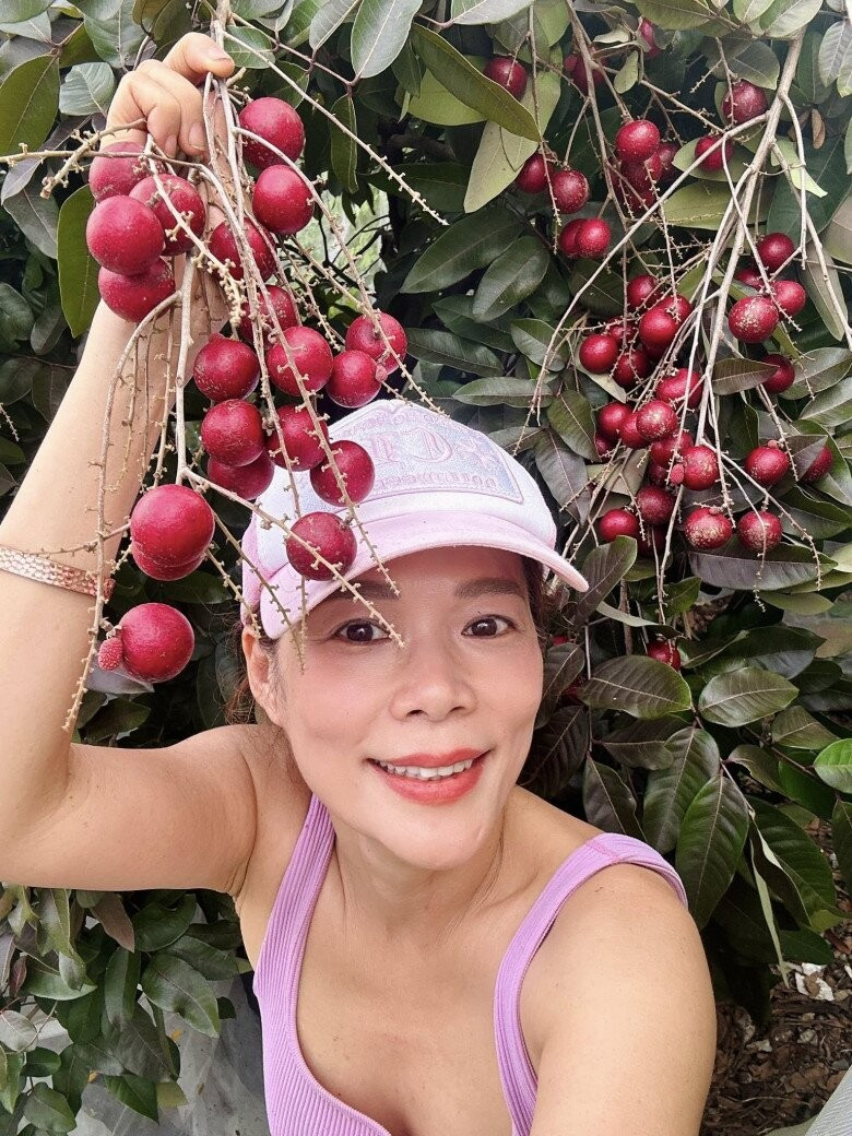 Mỹ Lệ rạng rỡ tạo dáng bên cây nhãn tím đang vào mùa. Những chùm quả chín mọng, căng tròn. Ảnh: FB Hoàng Thị Mỹ Lệ