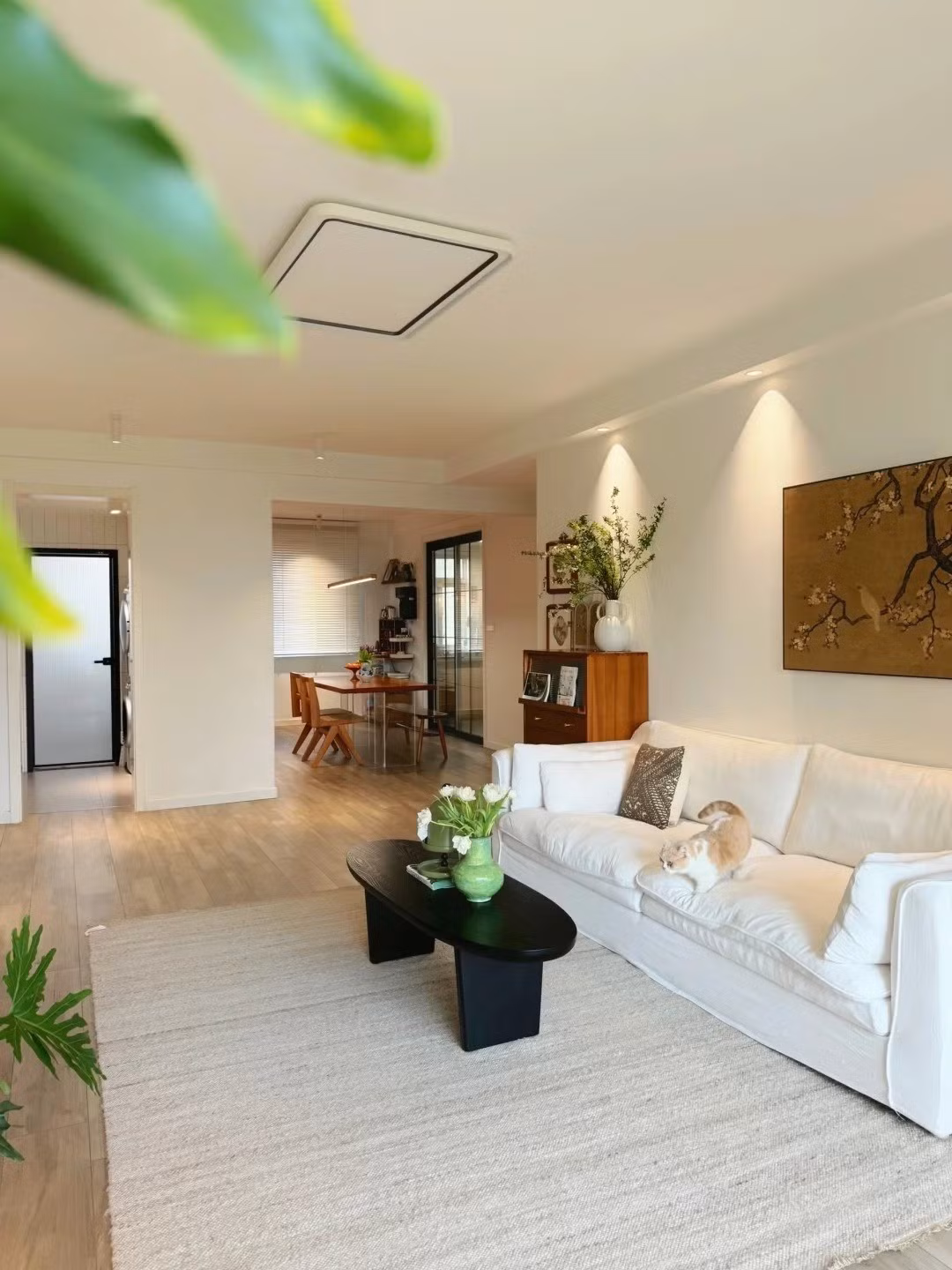 Bàn trà đen hình oval được tô điểm bởi chậu cây nhỏ và bình hoa nhài tươi. Ảnh: Sohu