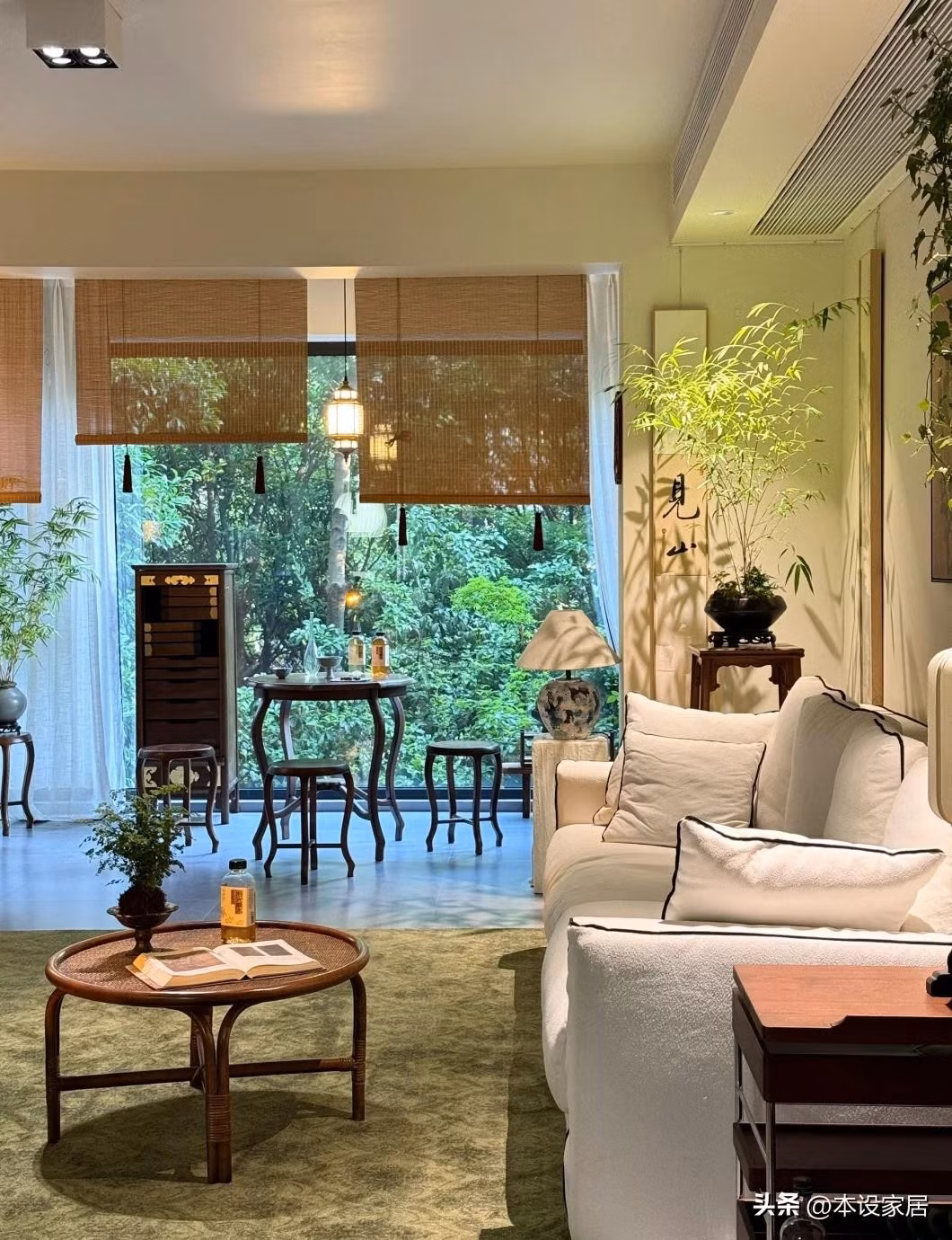 Phòng khách không cầu kỳ với sàn gạch xám, sofa vải trắng, tủ tivi mây, rèm tre, tranh thư pháp. Ảnh: Sohu