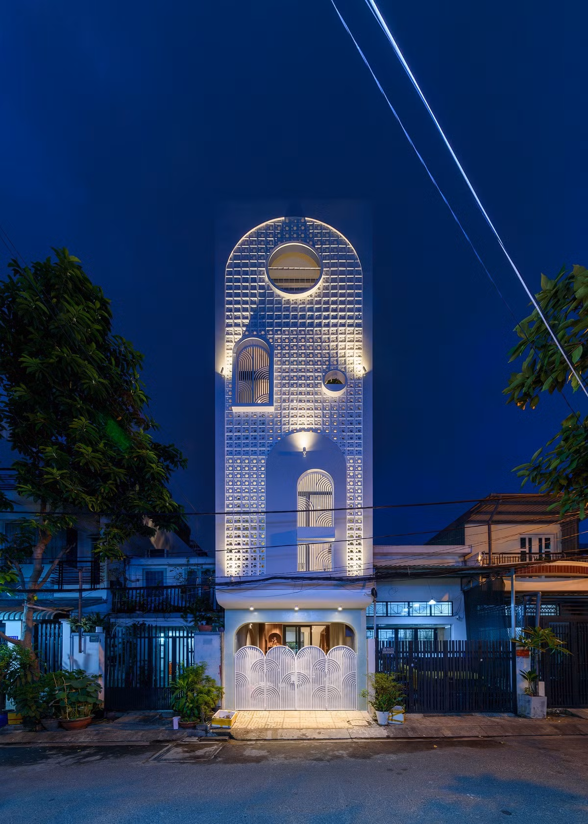 Lớp gạch bông gió giúp che bớt nắng hướng Tây cho các phòng ngủ phía trước đồng thời đảm bảo sự riêng tư, nhưng không làm mất đi sự thông thoáng. Ảnh: LonTon Studio