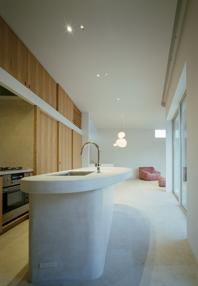 Đảo bếp được thiết kế hình cong, liên kết thị giác với tổng thể không gian. Ảnh: Katsuya Taira（studioREM）