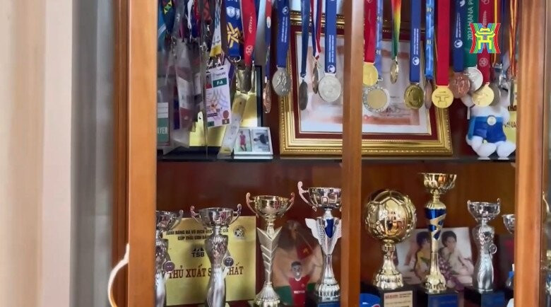 Cúp và bằng khen được gia đình đặt trang trọng trong tủ kính. Ảnh chụp màn hình