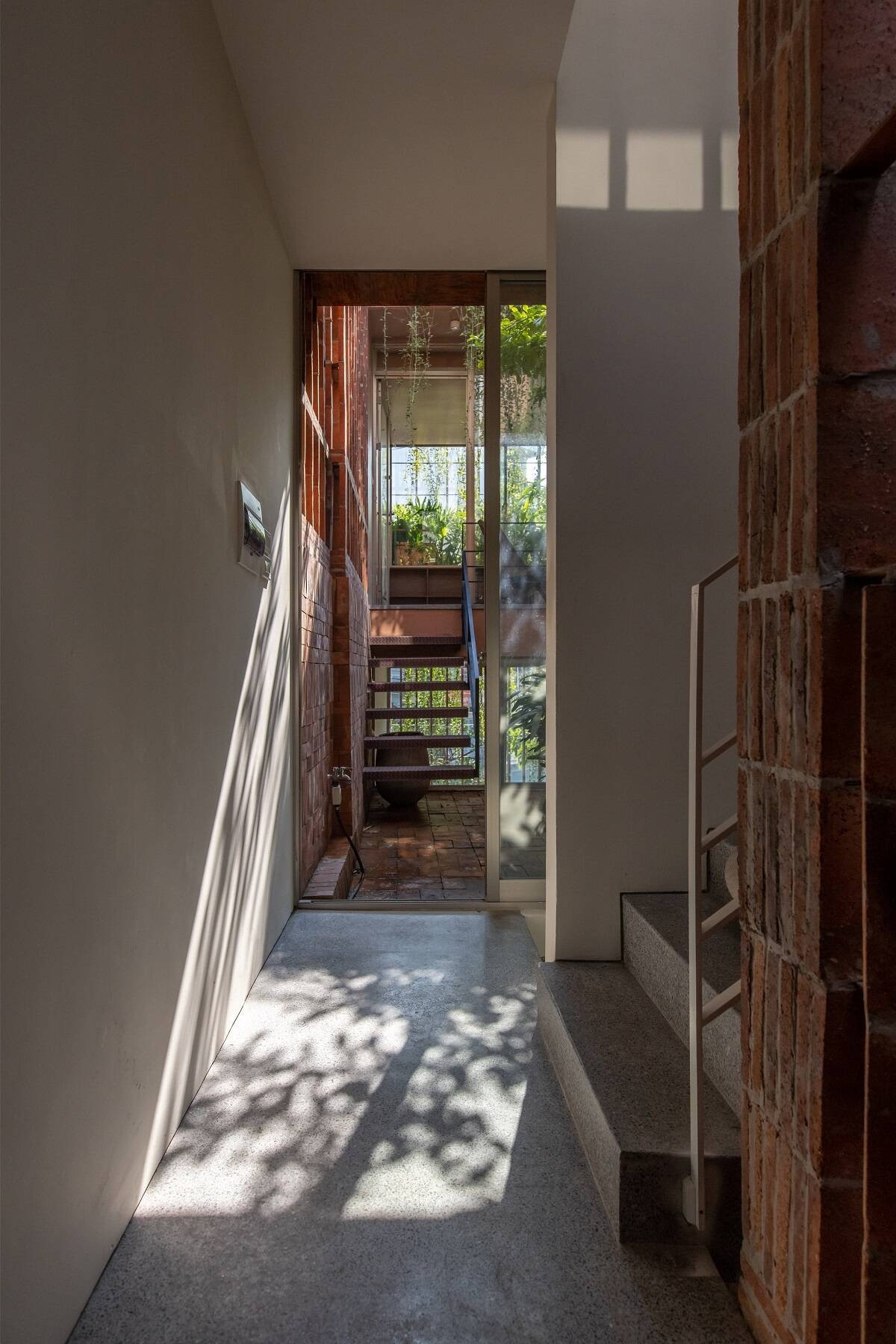 Cầu thang kết hợp với khu vườn ở tầng 2 đóng vai trò là trục kết nối giữa hai khối chức năng chính. Ảnh: Hoang le
