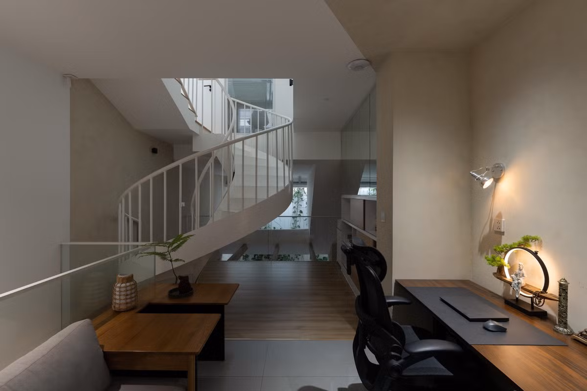 Tầng lửng là phòng khách và được kết nối bằng cầu thang cong, mang đến sự chuyển động mềm mại cho không gian. Ảnh: Quang Dam