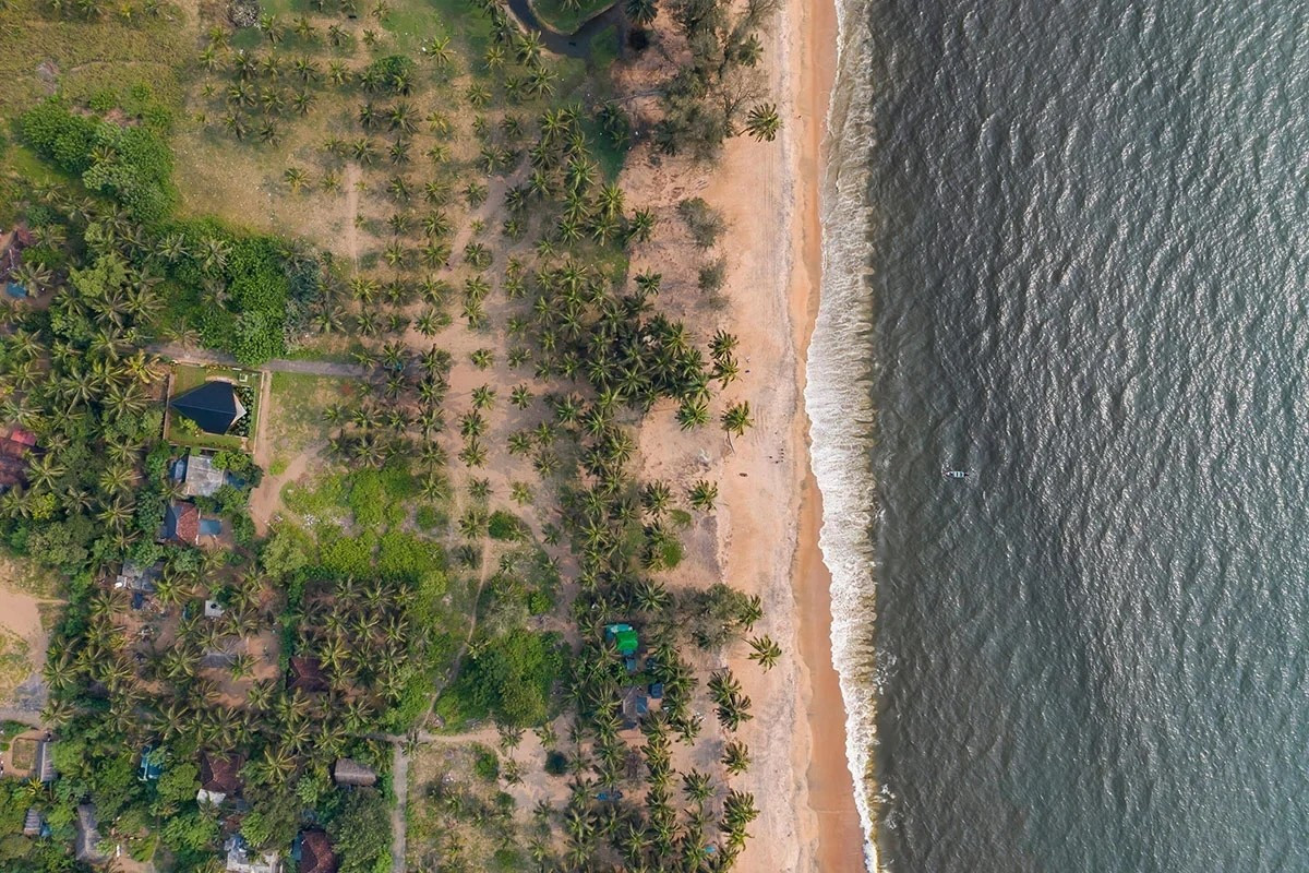 Căn nhà nằm gọn trên khu đất sát biển, bao quanh là vườn cây và lối dạo. Ảnh: Bhoomija