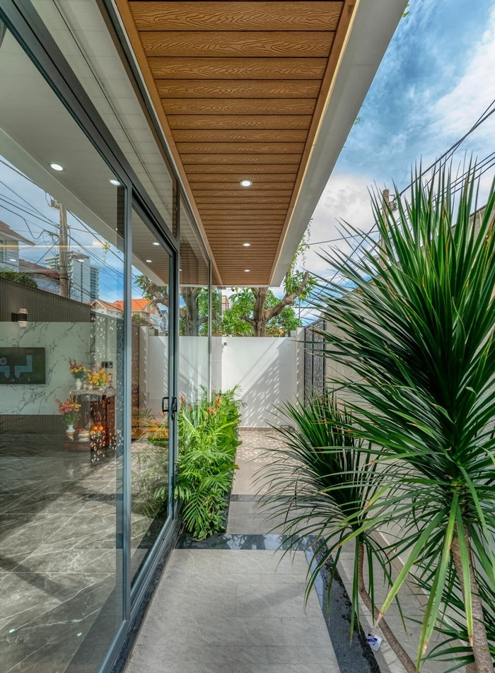 Hành lang nhỏ, khu vực sân chức năng tràn ngập ánh sáng và cây xanh. Ảnh: HAVA Studio