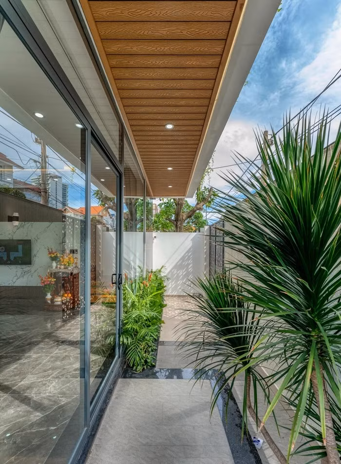 Hành lang nhỏ, khu vực sân chức năng tràn ngập ánh sáng và cây xanh. Ảnh: HAVA Studio