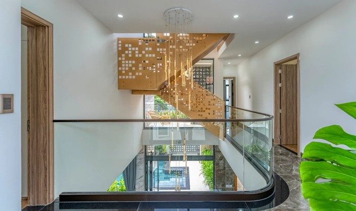 Cầu thang bọc thép phủ nhũ đồng như một món đồ trang sức nhỏ cho không gian chung. Ảnh: HAVA Studio