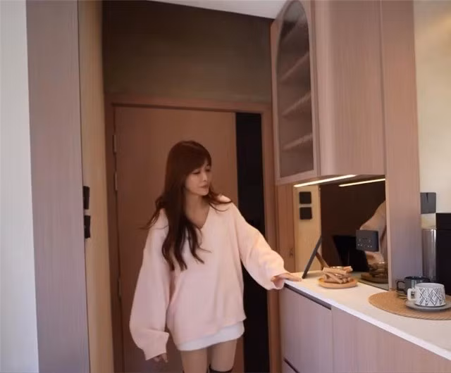 Ngay khu vực lối vào là tủ đựng giày và vật dụng cá nhân. Phần tủ thiết kế liền mạch với khu bếp, kéo dài lên cao nhằm tận dụng không gian theo chiều dọc. Ảnh: Toutiao