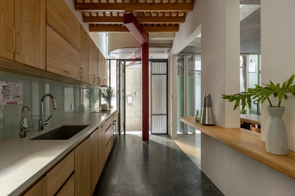 Những hạn chế về cấu trúc dẫn đến một hệ kết cấu được tổ chức xoay quanh một cột thép sơn đỏ đặt ở trung tâm, chạy xuyên suốt từ tầng một đến tầng bốn. Ảnh: Hoàng Lê