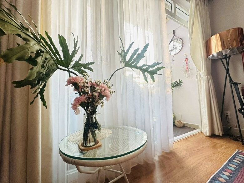 Bình hoa tươi khoe sắc bên bàn trà giúp không gian phòng khách tràn đầy sức sống. Ảnh: FBNV