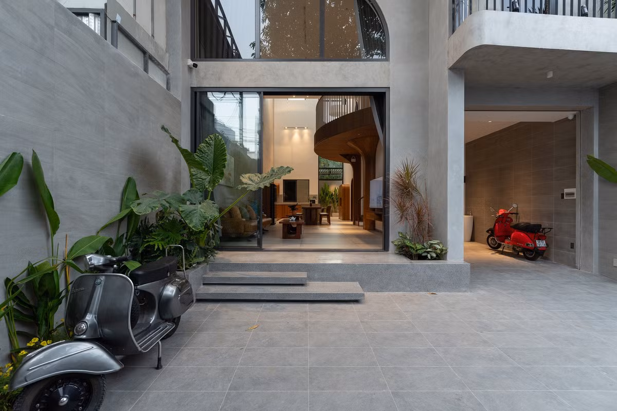 Công trình được thiết kế lùi về phía sau tạo khoảng sân trước trồng cây xanh, đồng thời là không gian trưng bày và chăm sóc những chiếc Vespa yêu thích. Ảnh: Quang Dam