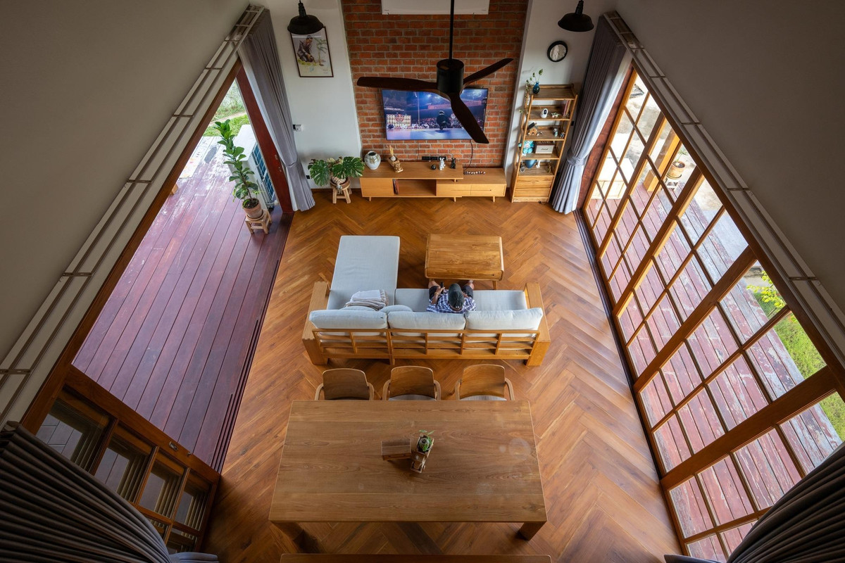 Không gian sinh hoạt chung thiết kế mở, kết nối phòng khách, bàn ăn và hiên ngoài trời. Ảnh: Rungkit Charoenwat