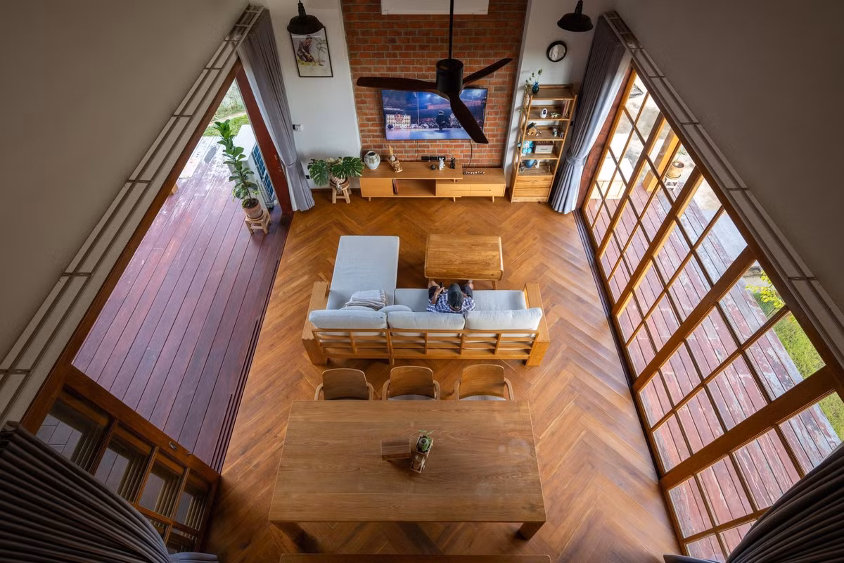 Không gian sinh hoạt chung thiết kế mở, kết nối phòng khách, bàn ăn và hiên ngoài trời. Ảnh: Rungkit Charoenwat