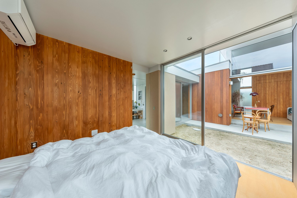 Phòng ngủ mở ra sân trong qua hệ cửa kính trượt. Ảnh: Studio ToLoLo