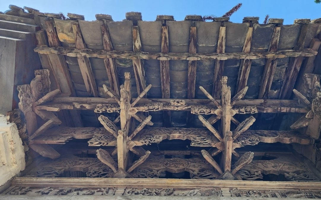 Cổng nhà uốn cong, trang trí cánh dơi. Mái gỗ chạm khắc tinh xảo. Ảnh: Vietnamnet