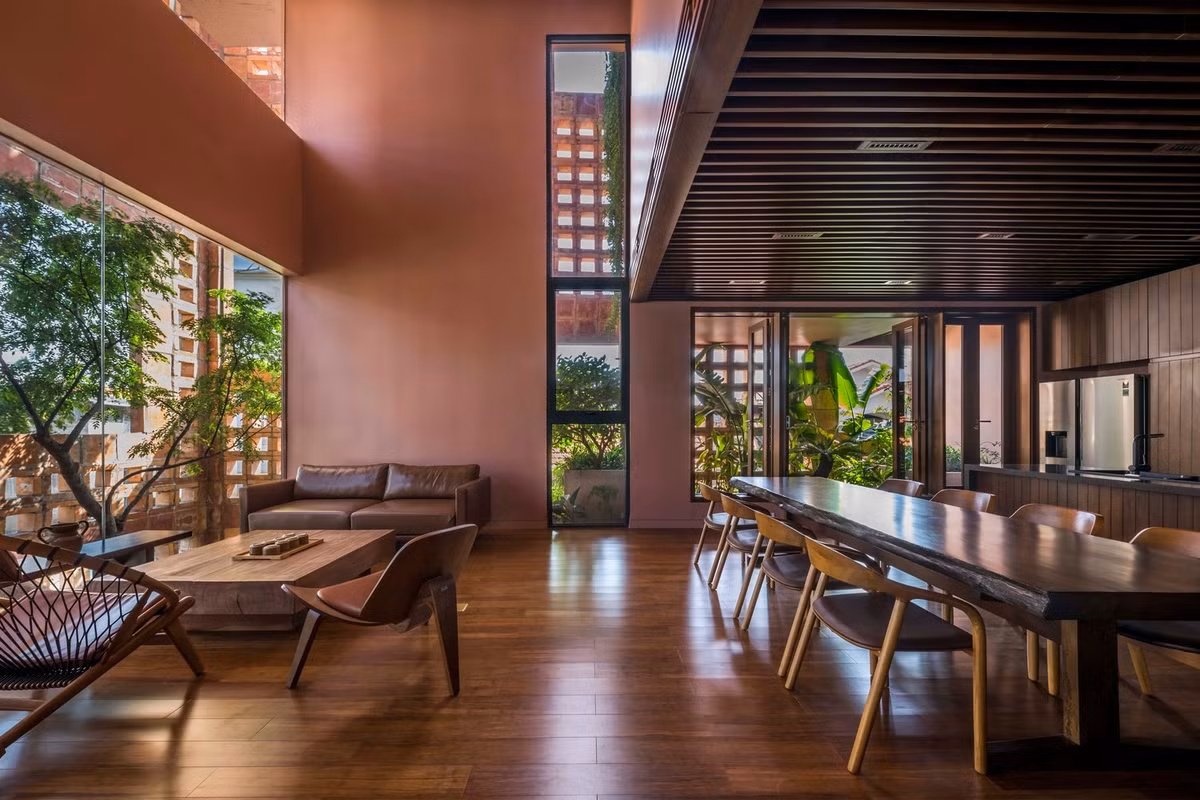 Đằng sau mặt đứng bằng gạch gốm là hệ cây xanh với cây thân cao vươn tán lá xanh rợp qua những ô cửa sổ lớn. Ảnh: Hiroyuki Oki