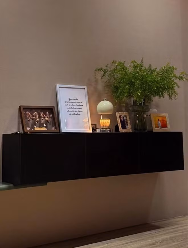 Góc kệ trang trí nhỏ nhưng tinh tế với đèn ngủ, bình cây xanh, khung ảnh...Ảnh: FBNV